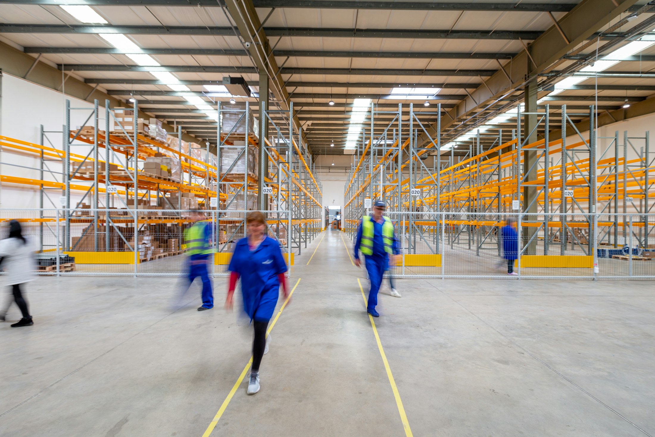 Workers walking through a warehouse aisle